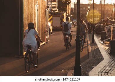 People Riding Bikes In Copenhagen, Denmark, Danish Popular Transport At Sunset