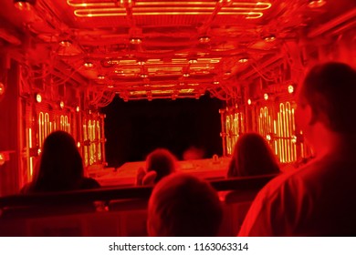 People Riding Indoor Tunnel Theme Park/amusement Park Ride. Red And Yellow Neon Lights.