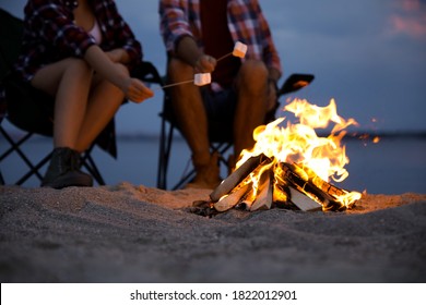 People Roasting Marshmallows Over Burning Firewood On Beach, Closeup