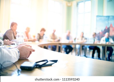People at a round table discuss different issues. Focus on hand - Shutterstock ID 1113593240