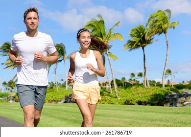 People Running In City Park. Happy Young Couple Living An Active Healthy Lifestyle Jogging Training Their Cardio During Summer On Road Or Neighborhood Street. Multiracial Group, Asian And Caucasian.