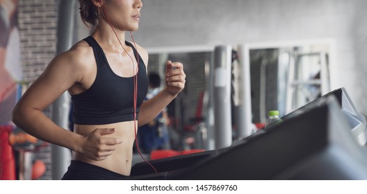 People running in machine treadmill at fitness gym, Young woman workout in gym healthy lifestyle, Young people running on a treadmill in health club - Powered by Shutterstock