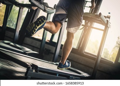 People Running In Machine Treadmill At Fitness Gym . Young Asian Man In Sportswear Running On Treadmill At Gym. Running Fast. Soft Focus.