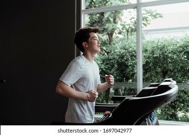 People Running In Machine Treadmill At Fitness Gym. Young Man Running On A Treadmill At Home. Male Athlete Workout On Running Exercise Machine.