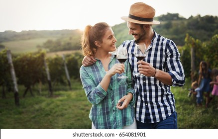 People sampling and tasting wines in vineyard - Powered by Shutterstock