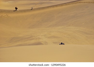 People Sandboarding On The Ancient Dunes Of The Namib Desert, Namibia, Africa.                  