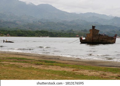 People Scrapping Old Ship Hull At A Beach In The Honduras