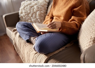 people, season and leisure concept - close up of woman in warm sweater reading book at home - Powered by Shutterstock