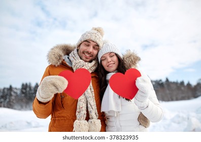 People, Season, Love And Valentines Day Concept - Happy Couple Holding Blank Red Hearts Over Winter Landscape