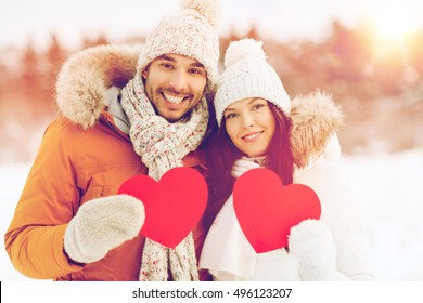 People, Season, Love And Valentines Day Concept - Happy Couple Holding Blank Red Hearts Over Winter Landscape