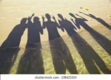 People Shadow On Beach Half On Sand And Half On Water