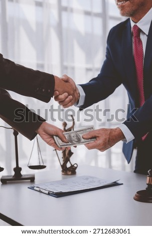 People shaking hands while transferring cash money, symbolizing a payment or illegal activity