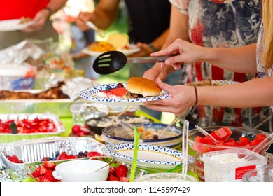 People Sharing Food At A Summer Potluck Barbeque