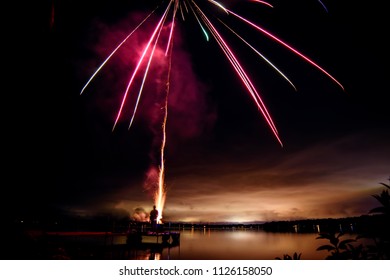 People Shooting Fireworks In Countryside On Lake Into Sky Holiday And Summer Celebration Fireworks Photography With Room For Copy For Canada Day, Or 4th Of July Background 