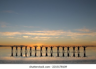 people silhouette in the Uyuni salt flat sunrise