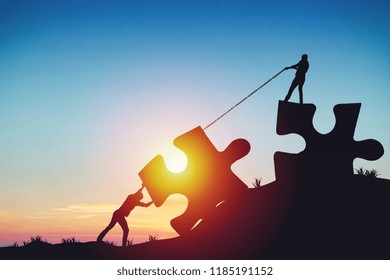 People Silhouettes Putting Puzzle Pieces Together On Sunlight Background. Business Idea Concept