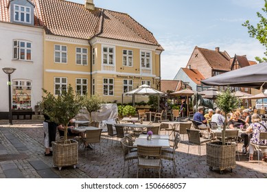 People sit and drink coffee in the square of Faaborg, Denmark, July 12, 2019