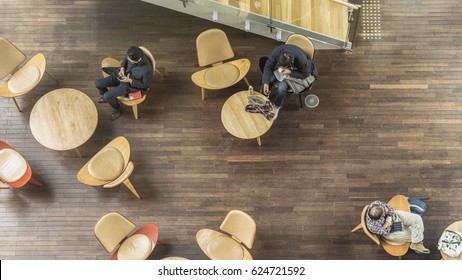 People Sit On The Chairs And Table On The Pattern Wood Floor And Direct Light On The Empty Ground (top Aerial View)