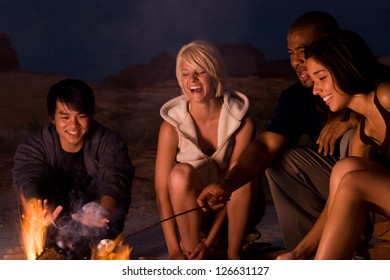 People sitting around a campfire at night - Powered by Shutterstock