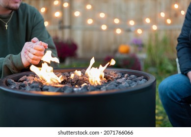 People Sitting Around An Outdoor Fire