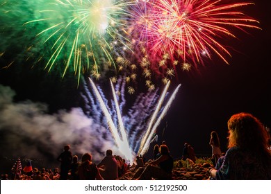 People sitting at the beach an watching the fireworks - Powered by Shutterstock