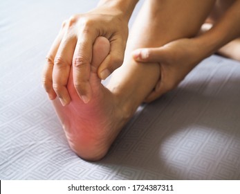 People Sitting In Bed With Foot Pain Use Hand To Massage Toe, Leg, Ankle And Soles To Relax And Relieve Pain.