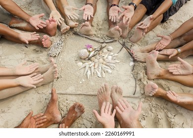 People sitting in a circle showing they hands and feet having seashells  decoration in the middle, praying the rain to start and stop Indonesian forest fires. - Powered by Shutterstock