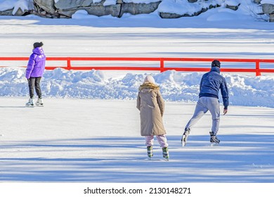 People Skate On An Outdoor Ice Rink On A Spring Day