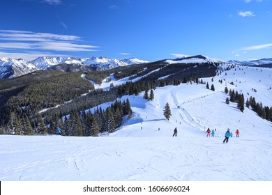 People skiing toward the back bowls and Blue Sky Basin at Vail Ski Resort in Colorado with copy space - Shutterstock ID 1606696024