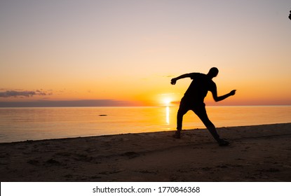 People Skipping Stones During Sunset. People Siluets During Golden Hour. Estonian Beach During Mid Summer Fest. Doing Sports During Sunset. Skipping Competition. Colorful Sunset