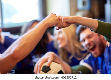 People, Soccer, Leisure And Sport Concept - Happy Friends Or Football Fans With Ball Celebrating Victory At Bar Or Pub