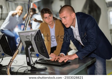People are solving puzzles on computer in escape room stylized like laboratory