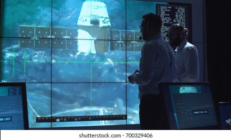 People In Space Mission Control Center Managing Spaceship Undocking. Elements Of This Image Furnished By NASA.