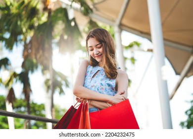 People spending money for trend fashion concept. Happy young adult southeast asian woman with shopping bags on day. Wear blue shirt with long hair. - Shutterstock ID 2204232475