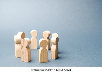 People Stand In A Circle On A Gray Background. Wooden Figures Of People. Discussion, Cooperation. Communication. Business Team, Teamwork, Team Spirit. Selective Focus