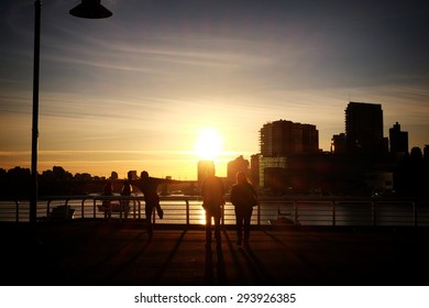 People Stand In An Early Evening Vancouver Sunset 