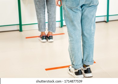People stand in line, legs close-up. Attention line on the floor of the store to maintain social distance. Concept of the coronavirus pandemic and prevention measures - Shutterstock ID 1714877539