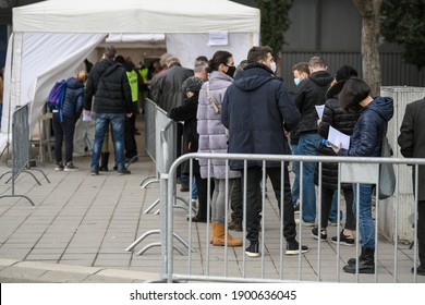 People stand in long queues on cold day in front of the checkpoint as they wait to receive the vaccine against corona virus - covid 19. Mass vaccination. Belgrade, Serbia 23.01.2021