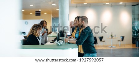People standing in the hall of a municipal office and talking with the administrators. Municipality office reception with people being assisted by the receptionist.