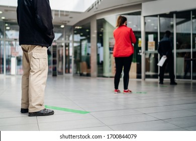 People standing in line front of bank/store due to coronavirus pandemic safety guideline.COVID-19 safe social distancing practice.Quarantine financial crisis,banking,loans.Spaced out queue.Crowd-limit - Shutterstock ID 1700844079