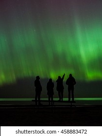 People Standing And Looking At Northern Lights