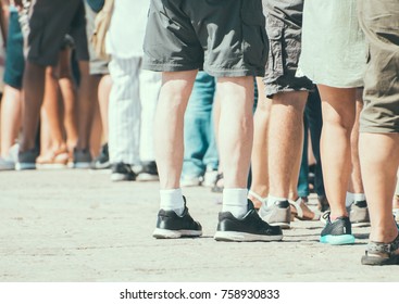 People Standing In A Queue On The Street.