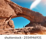 People standing underneath the big arch at Arches National Park