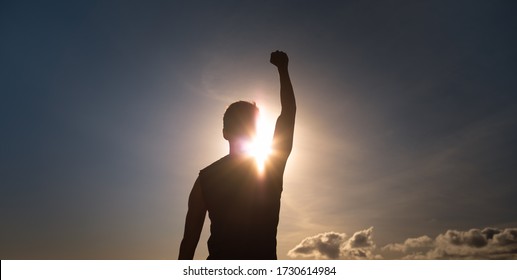 People, Strength, Power, And Never Giving Up Concept. Strong Man With Fist Up To The Sky. 