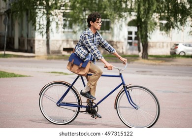 People, Style, Leisure And Lifestyle - Young Hipster Man With Shoulder Bag Riding Fixed Gear Bike On Tallinn City Street