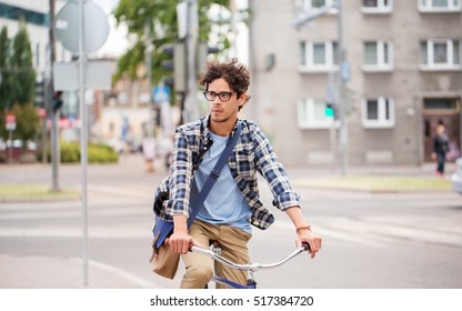 People, Style, Leisure And Lifestyle - Young Hipster Man With Shoulder Bag Riding Fixed Gear Bike On Tallinn City Street