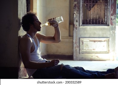 People, substance abuse and domestic violence. Portrait of young alcoholist drunk male drinking whisky at home