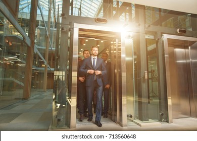 People In Suits Come Out Of Elevator And Walk Around The Office