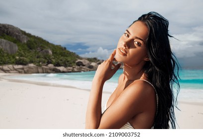 people, summer and swimwear concept - beautiful young woman in bikini swimsuit over tropical beach background in french polynesia