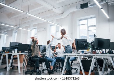 People talking and working together in the modern office near computers.